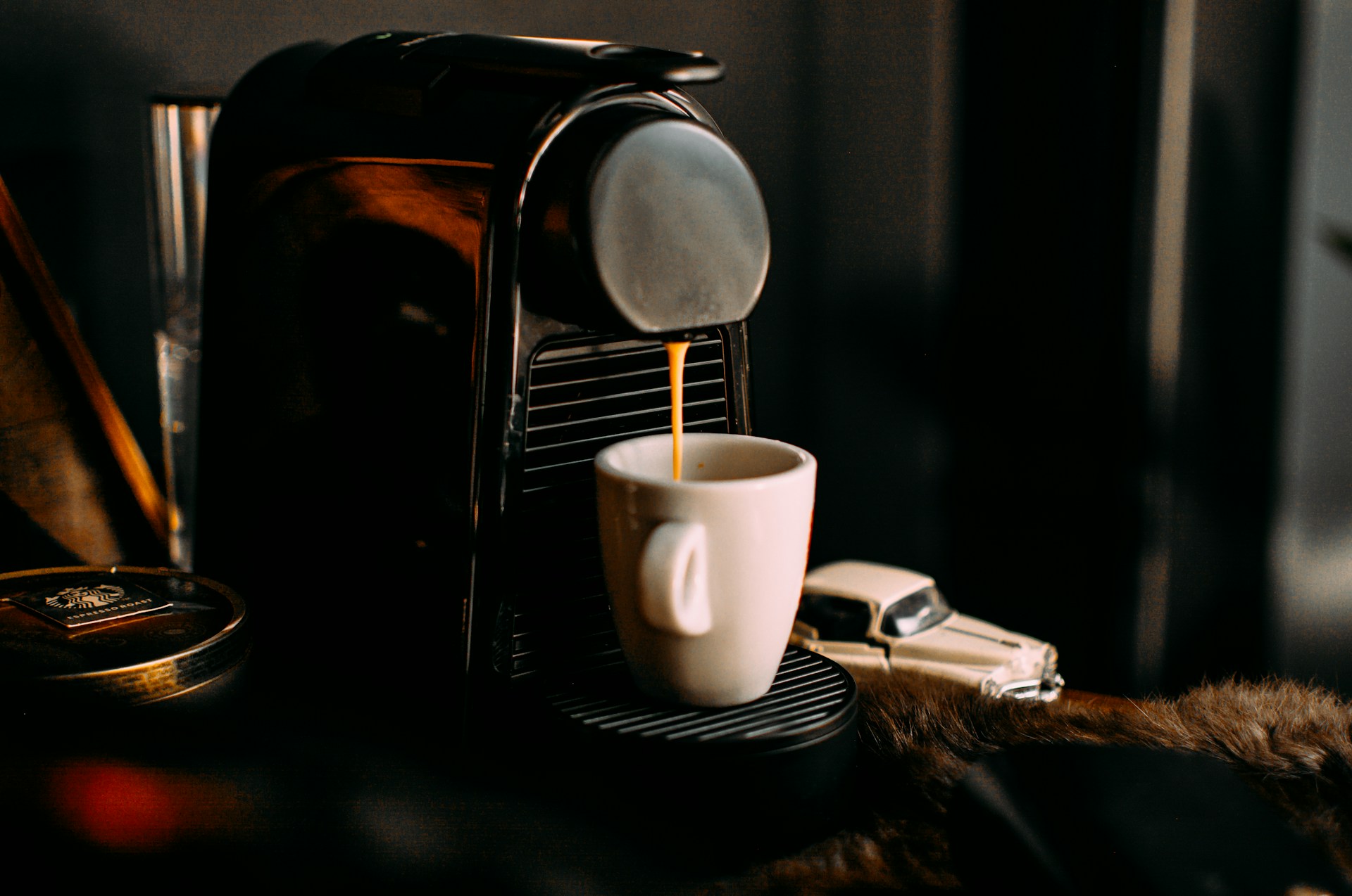 Capsule espresso machine brewing a fresh shot into a white cup