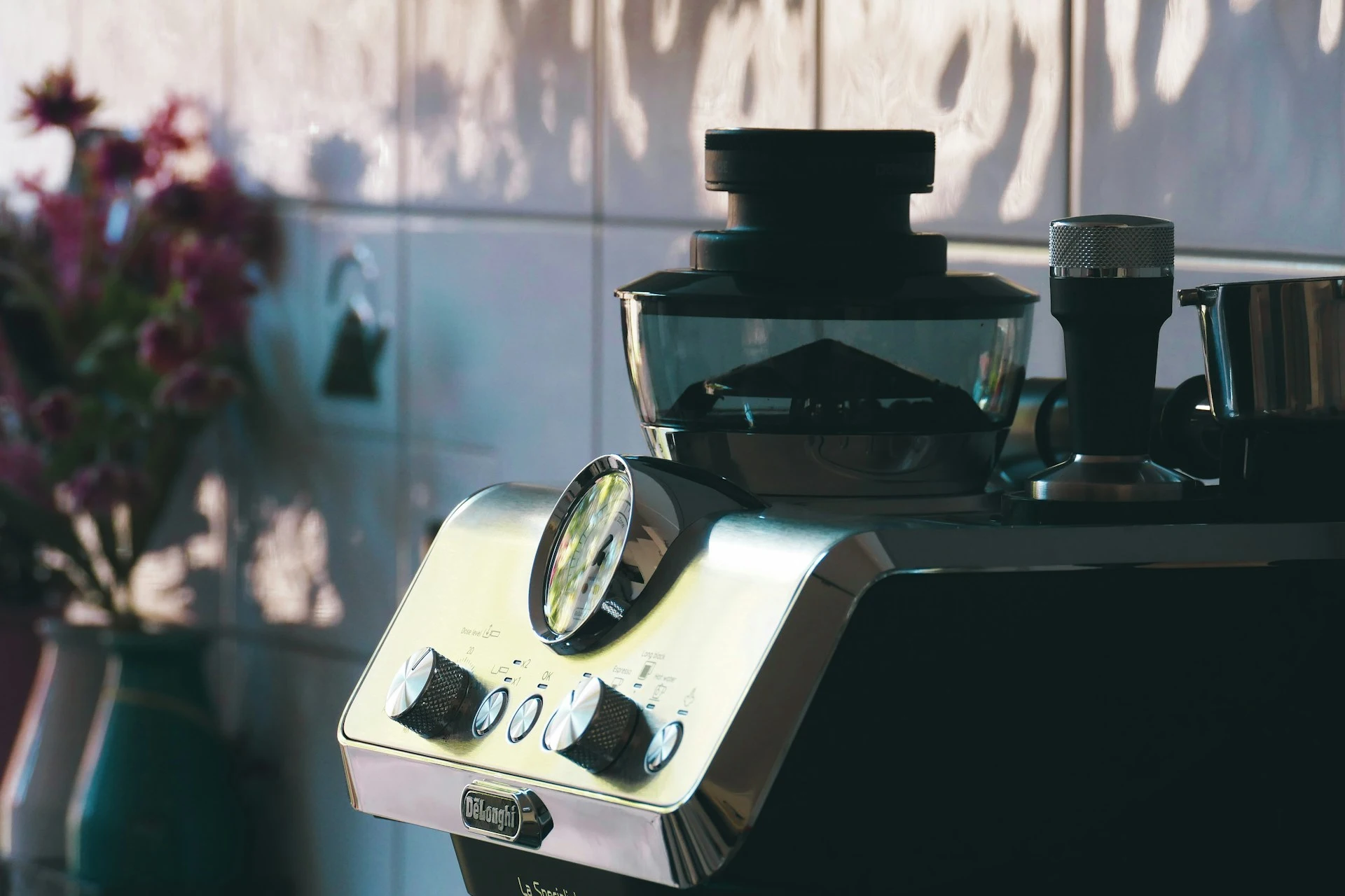 De'Longhi espresso machine with built-in grinder and tamper on a kitchen counter
